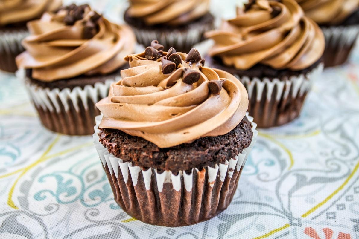Chocolate cupcakes topped with swirls of chocolate buttercream and chocolate chips
