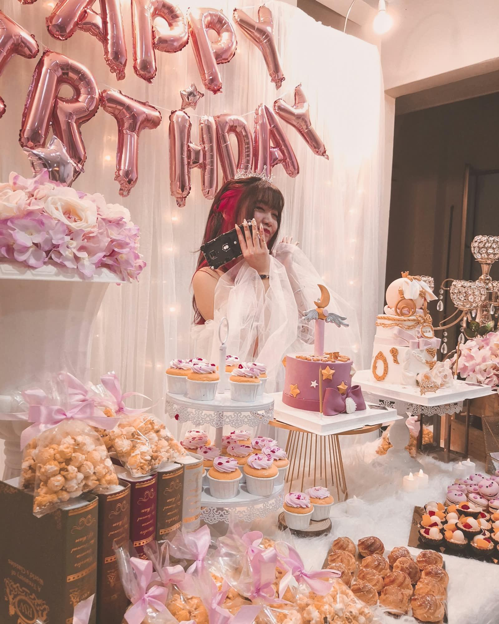Una mesa de cumpleaños llena de cupcakes decorados y globos que forman la palabra cumpleaños